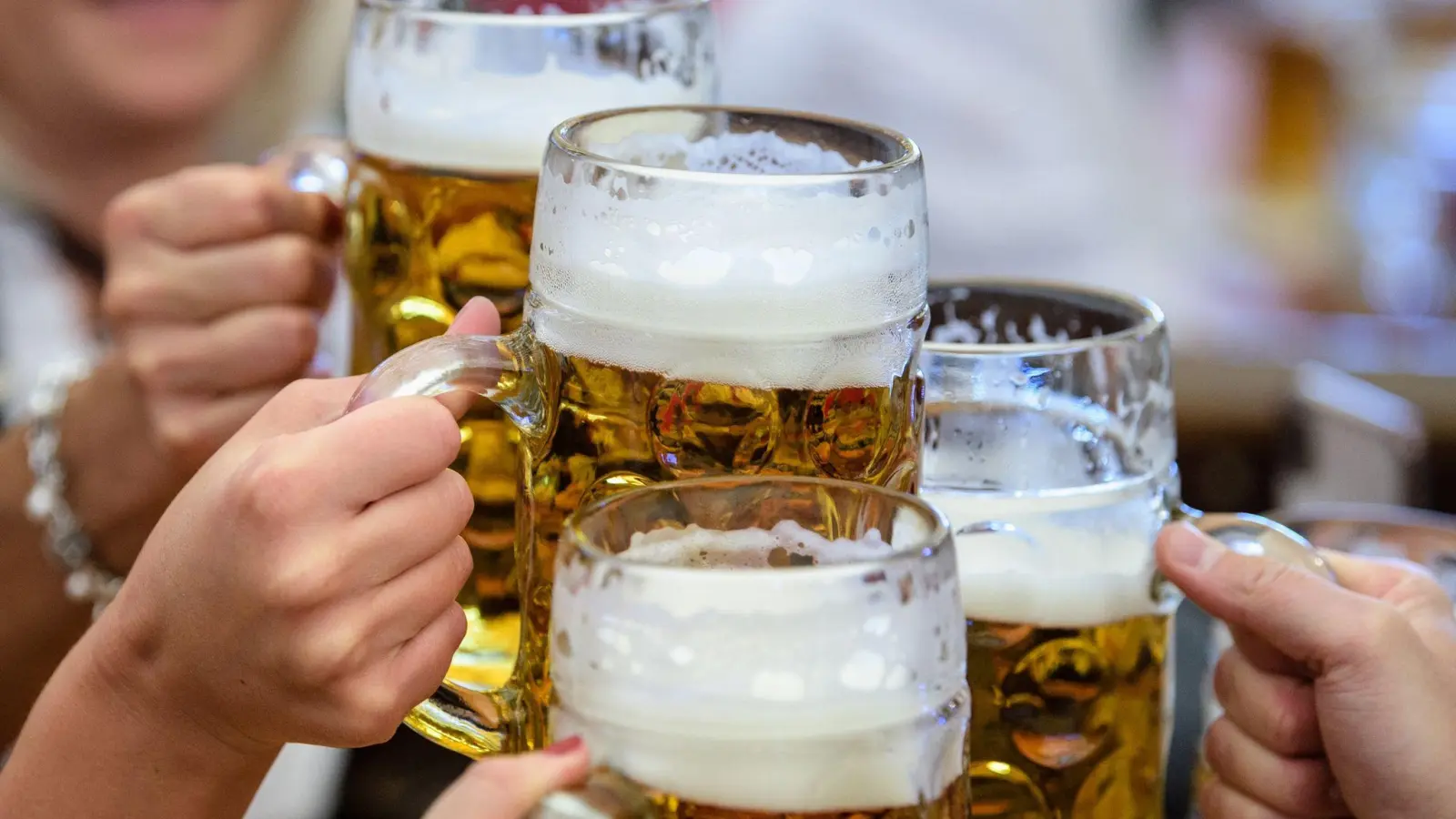 Besucher stoßen auf dem Münchner Oktoberfest mit Bier an. (Bild: Matthias Balk/dpa/Symbolbild)