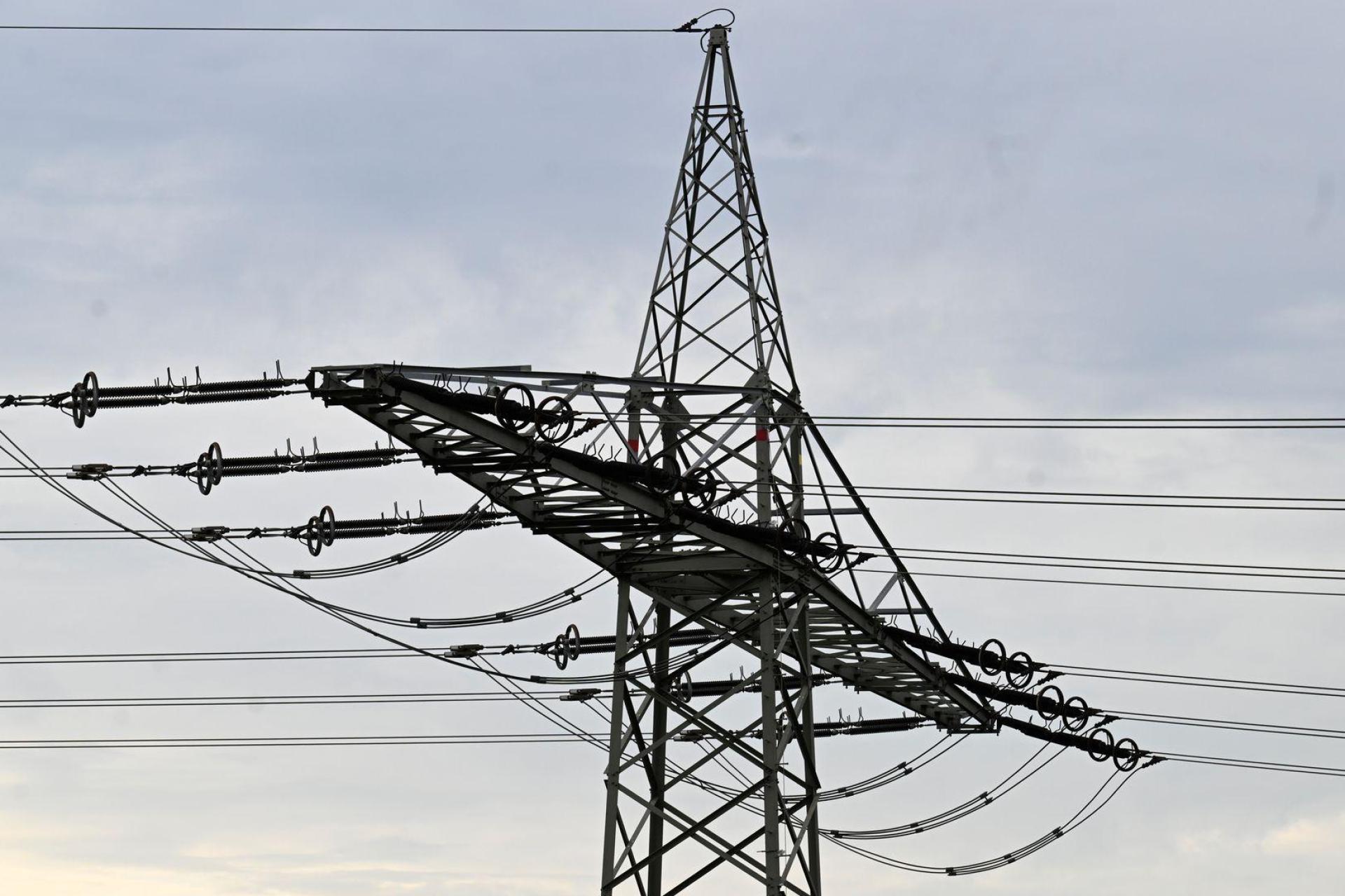 Ein Strommast steht vor grauen Wolken. In einigen Teilen von Luhe-Wildenau ist am Donnerstagmorgen der Strom ausgefallen. (Symbolbild: Roberto Pfeil/dpa)