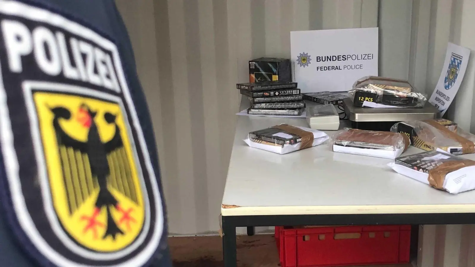 Ein Bundespolizist steht vor einem Tisch mit Feuerwerkskörpern. (Bild: Gregor Bauernfeind/dpa)