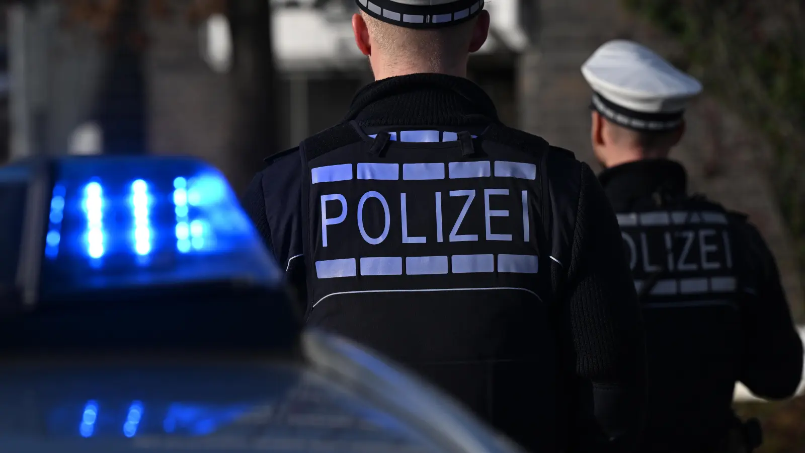 Das Logo der Polizei auf der Dienstkleidung von Polizisten. (Symbolbild: Bernd Weißbrod/dpa)