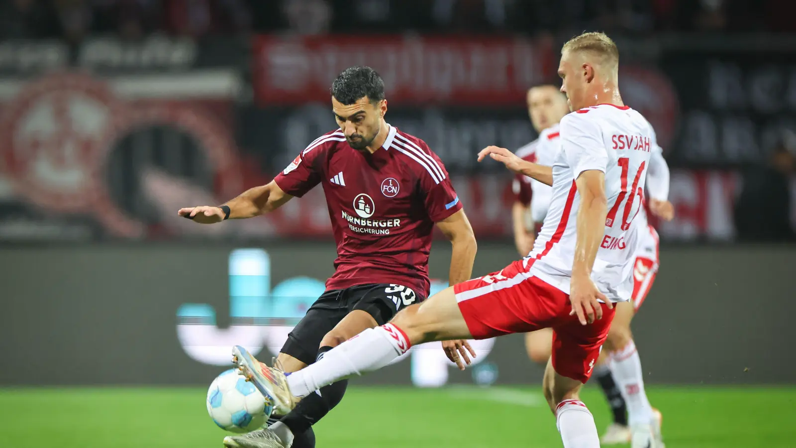 Der Nürnberger Mahir Emreli (links) kämpft mit dem Regensburger Louis Breunig um den Ball.  (Bild: Daniel Karmann/dpa)