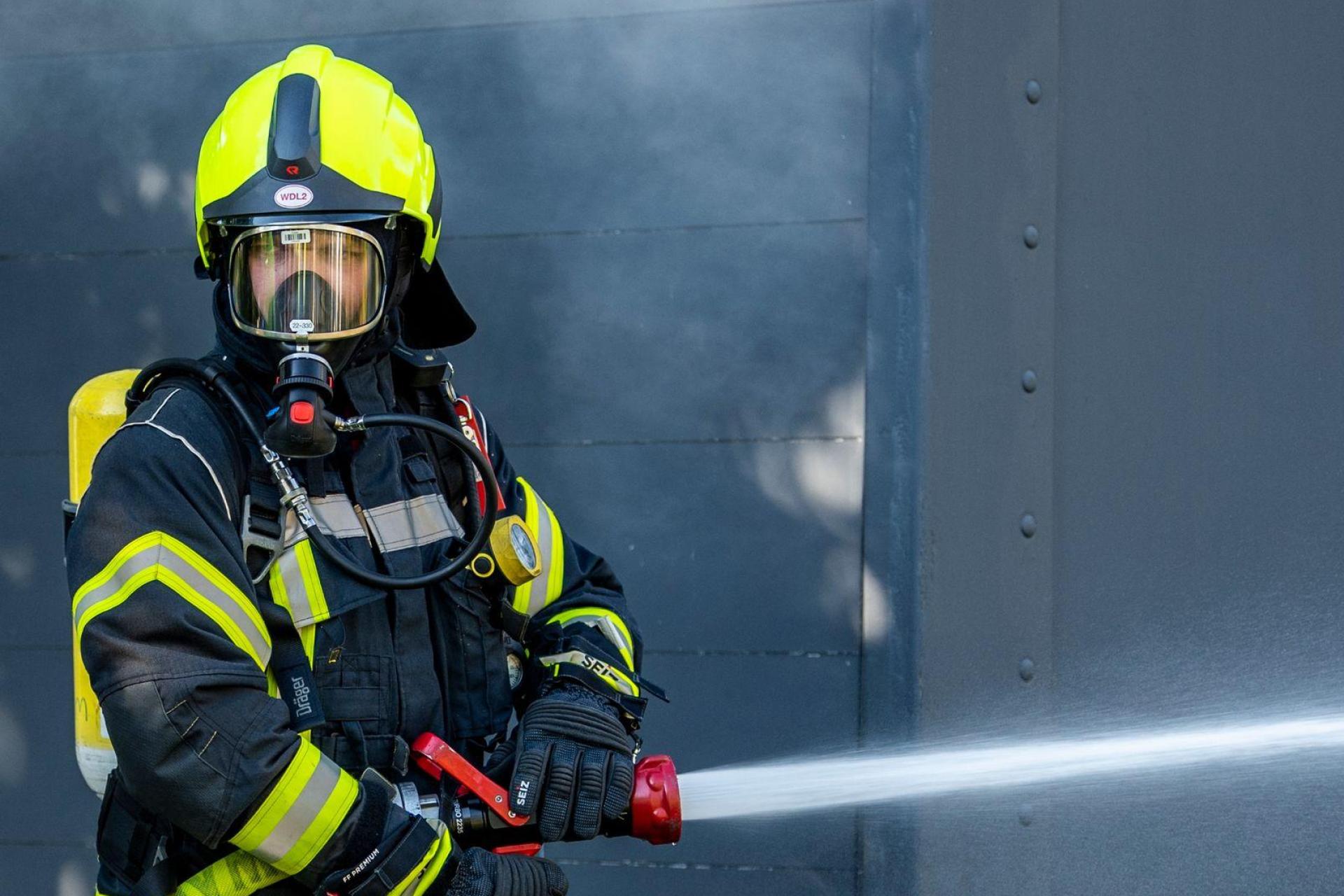 Ein Feuerwehrmann löscht am Brandort.  (Symbolbild: David Inderlied/dpa/Symbolbild)