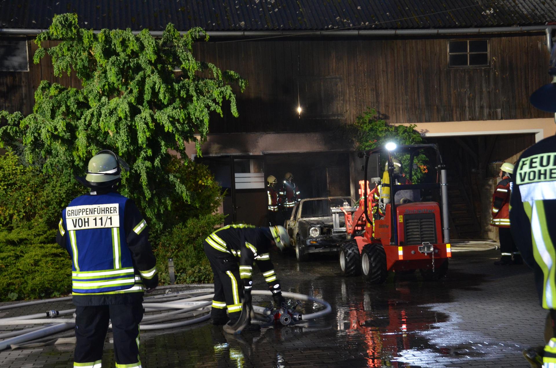 Mit schwerem Atemschutz rückten die Einsatzkräfte der Feuerwehr vor, um das verbrannte Fahrzeug aus der Garage zu ziehen. (Bild: dob)