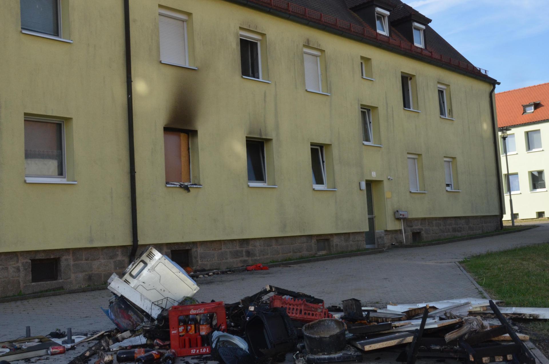 Am Morgen danach deuten die rußgeschwärzte Außenwand und zerstörtes Interieur auf den nächtlichen Brand in dem Mehrfamilienhaus hin. (Bild: Elisabeth Dobmayer)