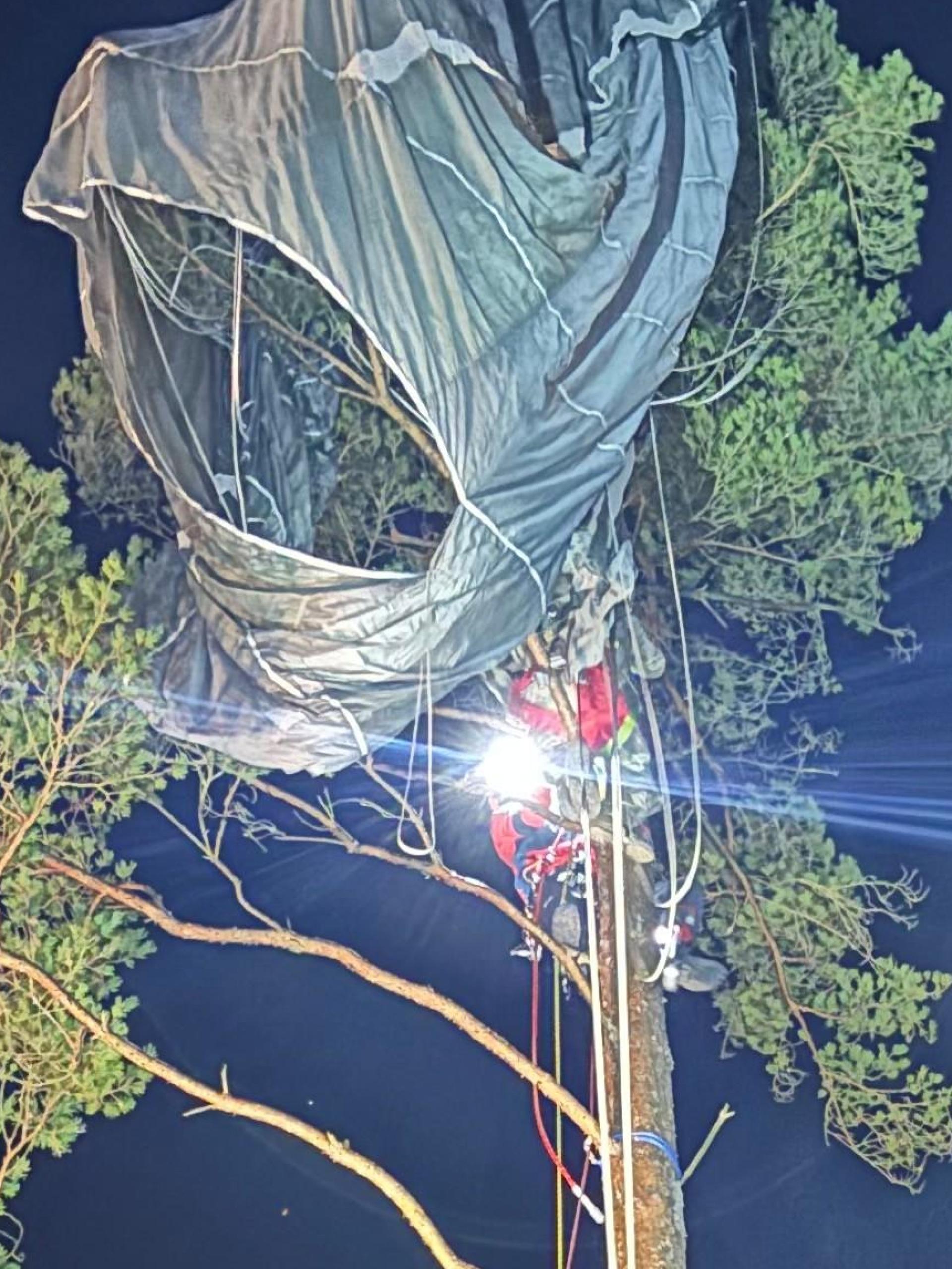 Die Bergwacht Weiden musste am Donnerstagabend auf dem Gelände des Truppenübungsplatzes Grafenwöhr einen Fallschirmspringer retten, der sich in der Krone einer Kiefer verheddert hatte. (Bild: Bergwacht Weiden/exb)