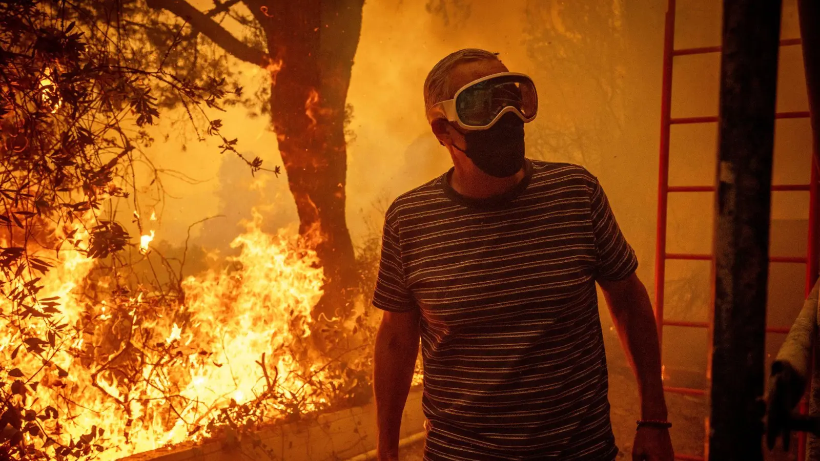 Will Adams beobachtet, wie sich die Flammen des Palisades-Feuers seinem Grundstück im Stadtteil Pacific Palisades von Los Angeles nähern. (Bild: Ethan Swope/AP/dpa)