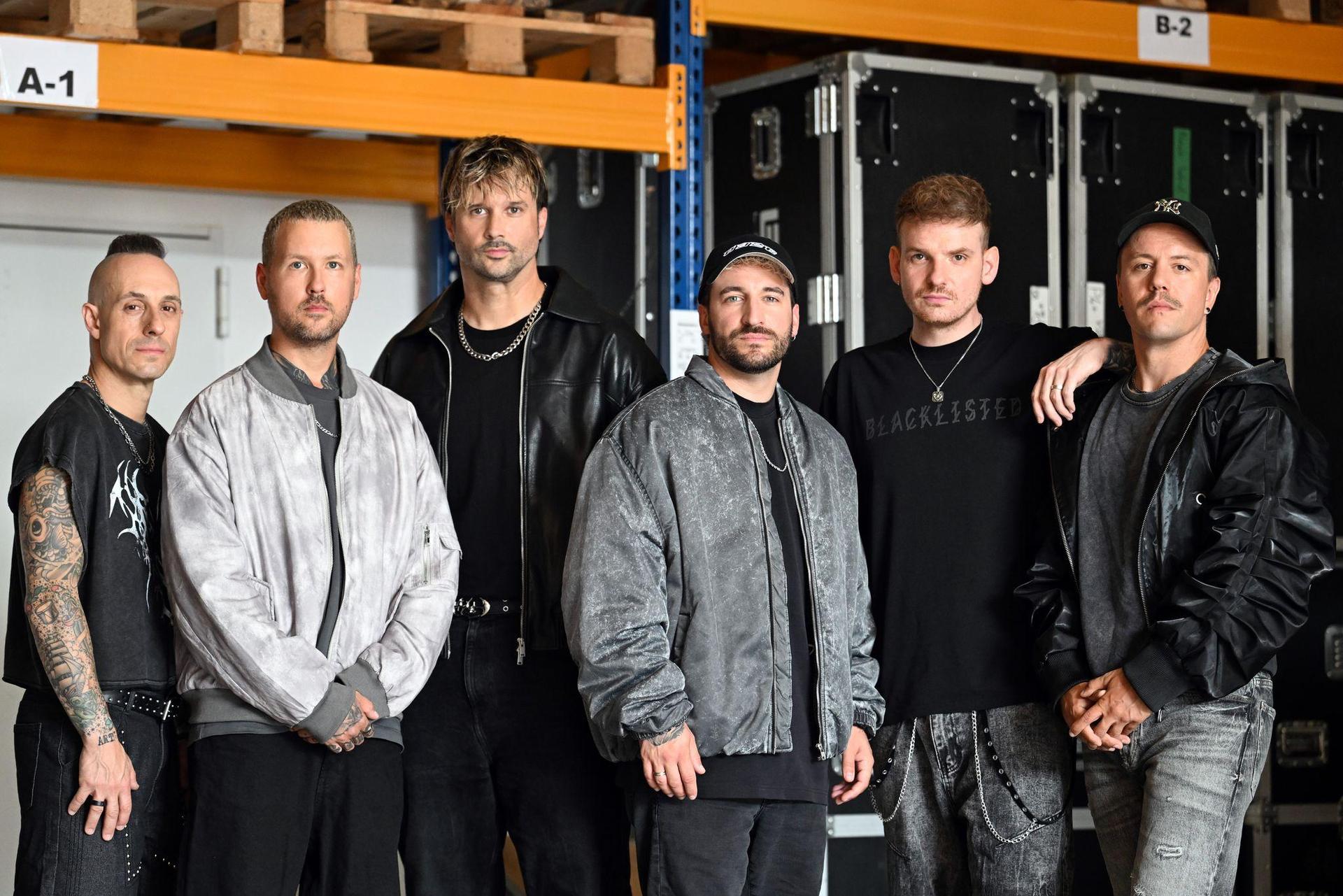 Die Band Electric Callboy steht in einer Halle in Castrop-Rauxel - von links nach rechts: Frank Zummo, Daniel Haniß, Kevin Ratajczak, Nico Sallach, Pascal Schillo und Daniel Klossek. (Archivbild) (Bild: Federico Gambarini/dpa)